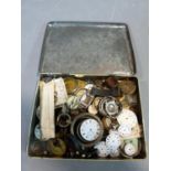 A collection of antique and vintage pocket watch and wrist watch parts in a vintage biscuit tin. The