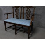 A George III Chippendale style mahogany double chair back settee with pierced splat and drop in seat