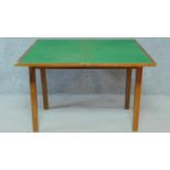 A mid 20th century teak foldover top card table with baize lining on square section supports. H.69