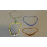 A collection of vintage Czech glass necklaces including an opaque yellow and white glass necklace, a