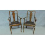 A pair of Edwardian oak armchairs with leather drop in seats on cabriole supports. H.103cm