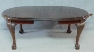 A late 19th century mahogany extending dining table on cabriole supports terminating in ball and