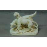 A pair of Royal Dux white porcelain hand painted hunting dogs on grass. Makers stamp to base. H.29