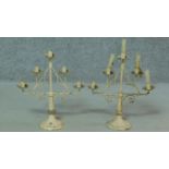 A pair of antique painted iron candelabras with a stylised foliate design. H.42cm