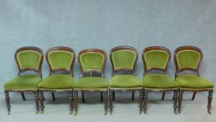 A set of six Victorian mahogany dining chairs in green velour upholstery raised on turned tapering