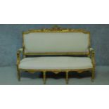 A Louis XVI style carved giltwood sofa with cream upholstery raised on turned tapering supports. H.