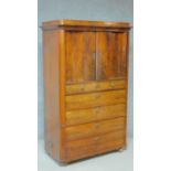 A 19th century Continental flame mahogany press cupboard with panel doors enclosing shelves and