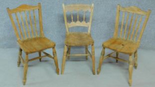 A pair of rustic elm dining chair on turned stretchered supports together with a similar example.