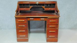 A late 19th century oak roll top desk with tambour shutter and fitted interior on twin pedestal base