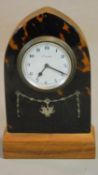 A tortoiseshell cased lancet shaped mantel clock with white metal swag inlay. Swiss made movement.