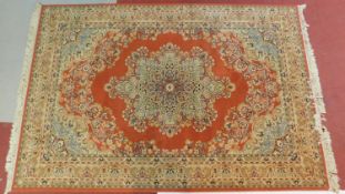 A Tabriz carpet with central floral medallion on rouge ground within floral multi-border. 200x315cm