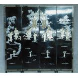 A Japanese black lacquered three fold and four panel screen with mother of pearl and bone inlay.