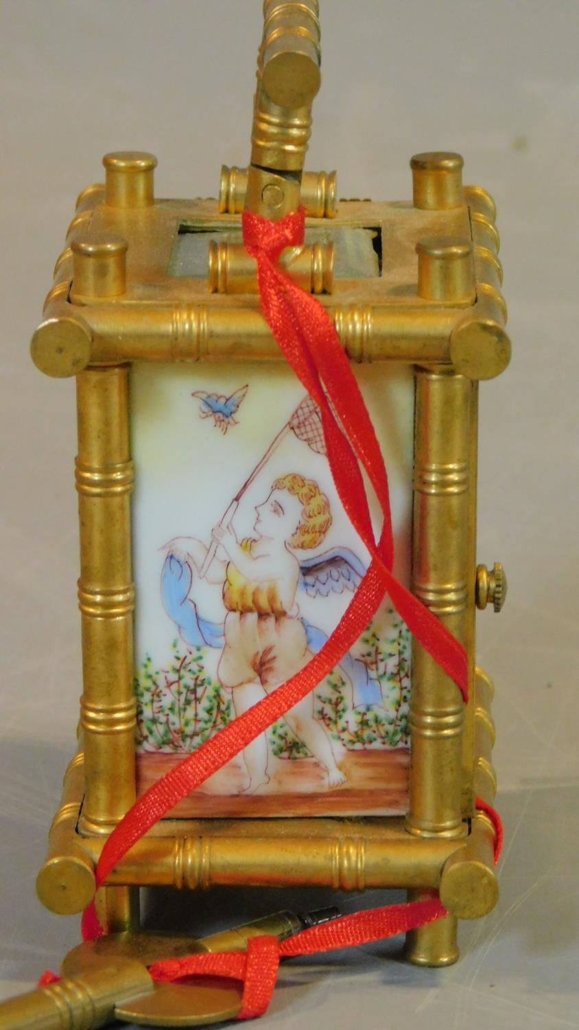 An antique gilt carriage clock, with enamel painted panels with cherubs catching butterflies. - Image 3 of 6