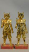 A pair of early 20th century South East Asian lacquered carved gilt wood statues of Oriental warrior
