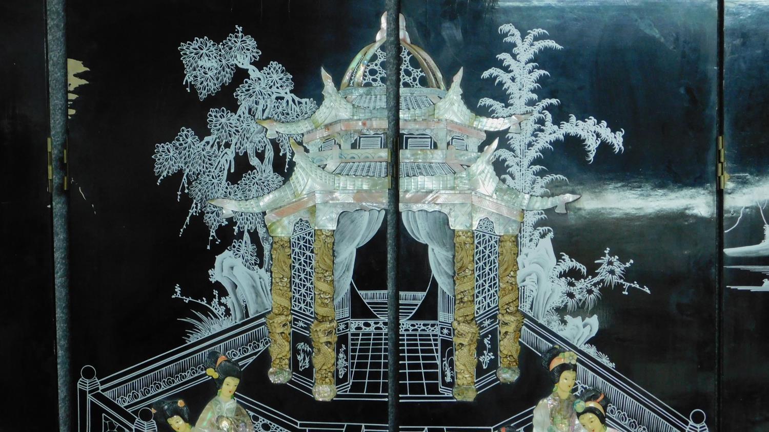 A Japanese black lacquered three fold and four panel screen with mother of pearl and bone inlay. - Image 13 of 23