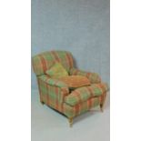 A Howard style armchair on turned tapering supports in tartan upholstery. H.86cm