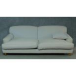A contemporary two seater sofa in cream upholstery. H.80 W.220 D.115cm
