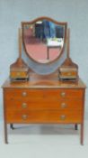 An Edwardian mahogany and satinwood strung dressing table fitted with central bevelled plate