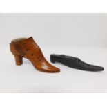 An antique treen wooden pin cushion in the form of a heeled boot, with tacks for buttons and