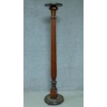 A 20th century mahogany torchere with reeded column on stepped circular base. H.169cm
