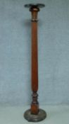 A 20th century mahogany torchere with reeded column on stepped circular base. H.169cm