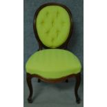 A Victorian rosewood balloon back nursing chair in lime green fabric painted upholstery on