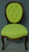 A Victorian rosewood balloon back nursing chair in lime green fabric painted upholstery on