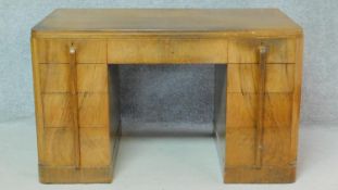 An Art Deco figured walnut pedestal desk fitted with an arrangement of nine drawers. H.73 W.122 D.