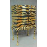 A mid 20th century drinks cabinet fitted revolving glazed interior with later painted tiger stripes.