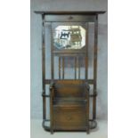 An antique style oak hallstand fitted with mirror above box seat with lift up top enclosing shoe