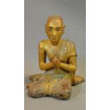An early 20th century South East Asian lacquered carved gilt wood statue of Bhuddha's desciple