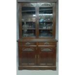 A late 19th century carved mahogany library bookcase with glazed doors above a pair of drawers and