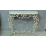 A mid 20th century white painted wrought iron console table with shaped marble top on scrolling