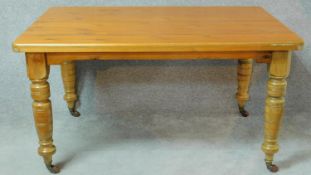 A late Victorian dining table with pitch pine top on turned tapering supports. H.73 W.137 D.94cm