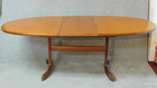 A 1970's vintage teak G-Plan dining table fitted with swivel fold out leaves to the underside. H.