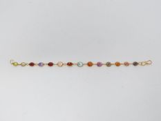 A bespoke heated coloured sapphire and yellow metal chain bracelet (tested 14 carat gold). Set