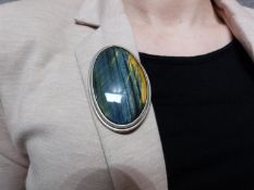 A bespoke Hawks Eye (possibly Pietersite) cabochon and white metal (tested silver) statement brooch,