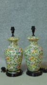 A pair of hand painted Oriental style vase shaped table lamps on wooden bases. Decorated with