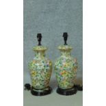 A pair of hand painted Oriental style vase shaped table lamps on wooden bases. Decorated with