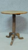 An early 19th century oak occasional table on ring turned pedestal support with tripod cabriole
