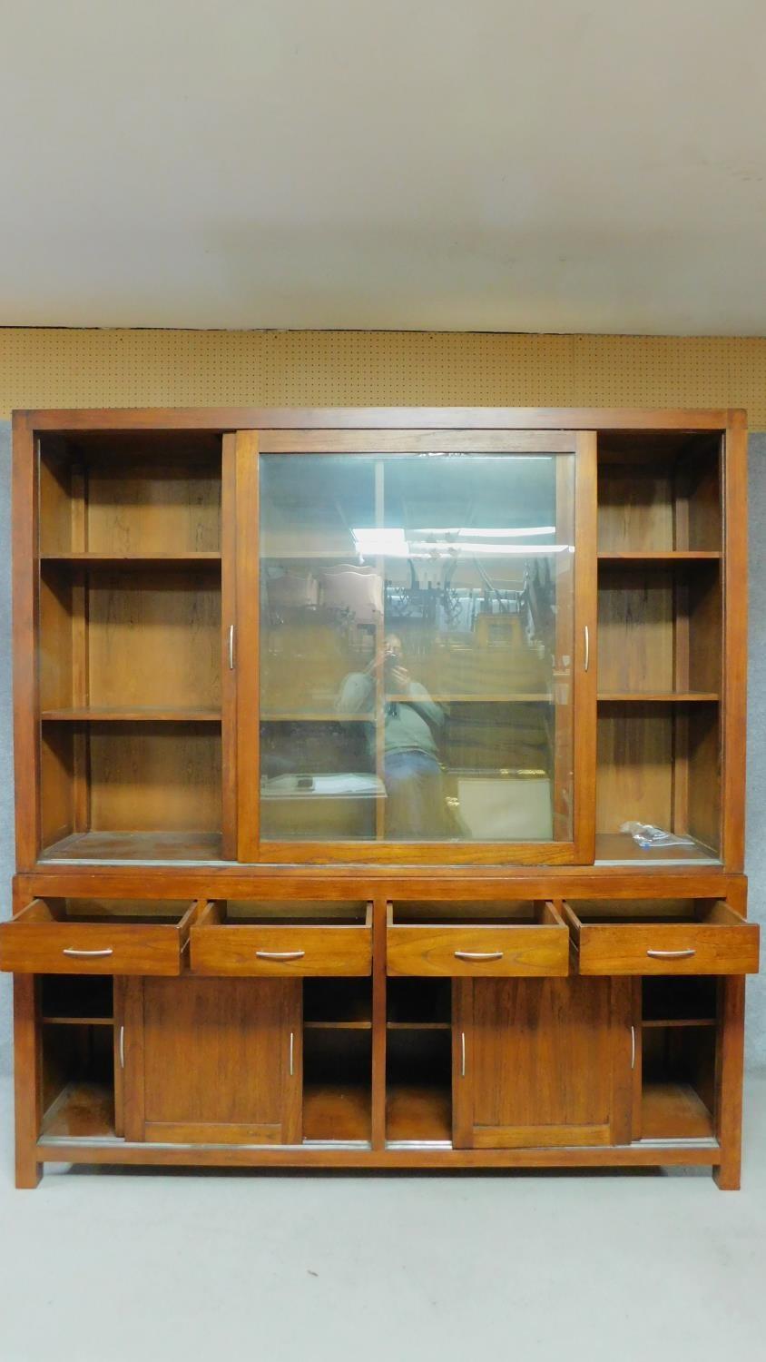 A large Eastern teak library bookcase with glazed sliding doors to the upper section above base - Image 2 of 7