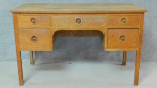A Heal's limed oak kneehole desk with Heal and Son disk inset to drawer. H.76 W.122 D.59cm