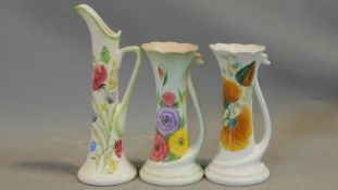 Three vintage hand painted Radford Pottery jugs. Two with swan form handles, scalloped rims and bold