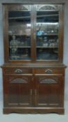 A late 19th century carved mahogany library bookcase with glazed doors above a pair of drawers and