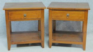 A pair of Eastern teak bedside tables with frieze drawers on square supports united by undertier.