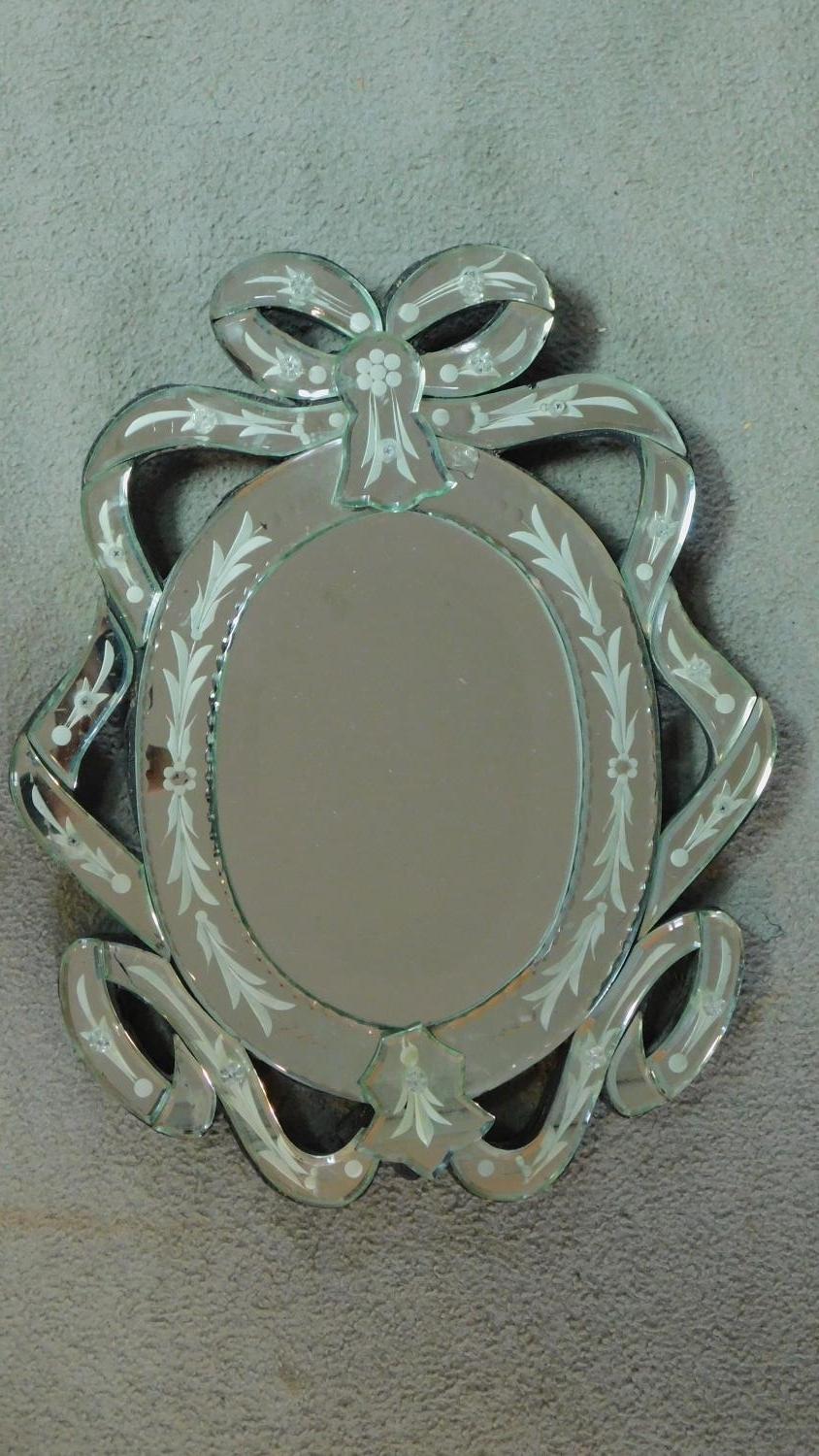 A Venetian style wall mirror with glazed scrolling ribbon borders. 46x36cm