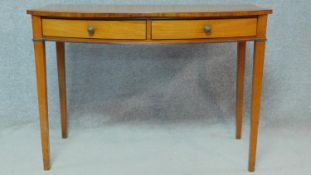 A Georgian mahogany bow fronted hall table with plate glass top and a pair of frieze drawers with