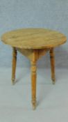 An antique pine cricket table on three turned tapering supports. H.69 W.68 D.68cm