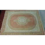 A large Persian carpet with central floral medallion on rouge ground and floral borders. 380x270cm