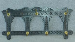 A Victorian carved oak wall hanging coat rack, retailers label to the back. H.48 W.106cm